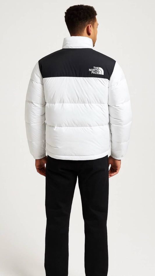 Person wearing a white and black puffer jacket with 'The North Face' logo on a white background